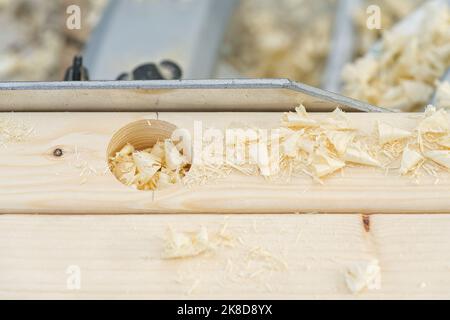 Crpenter builder working overall equals a wooden bar with a milling machine in the workshop Stock Photo