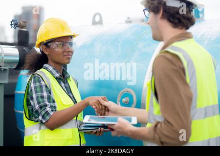 Young woman and man engineer doing agreement and handshake in the factory, mechanic and partner inspector plumber valve and deal for success together, Stock Photo