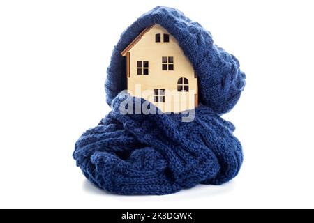 Wooden toy house with warm hat and scarf isolated on white background Stock Photo