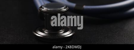 Medical stethoscope instrument on black surface, tool for patient diagnostic Stock Photo