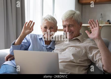 Attractive older wife and husband using laptop start video call Stock Photo