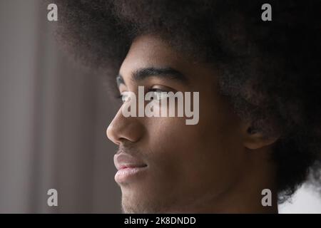 Serious or concerned African guy with curly hair staring aside Stock Photo