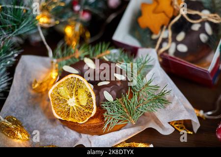 New Year's cupcake decorated with a dried orange slice and spruce branches on the background of Christmas decor Stock Photo