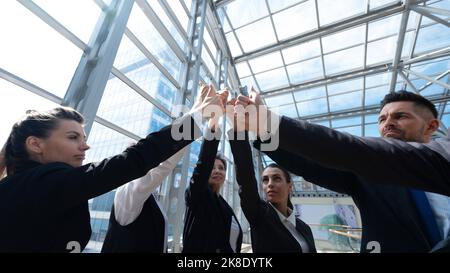 Happy successful multiracial business team giving a high fives gesture as they laugh and cheer their success Stock Photo