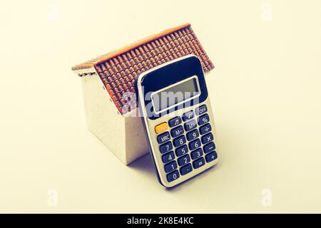 Model house and calculator placed on white background Stock Photo