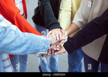 Multiracial young people stacking hands together outdoor Stock Photo