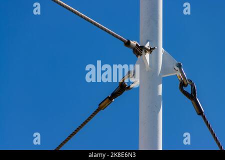 Metal pole with three steel cables attached for stability Stock Photo