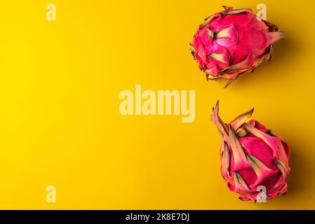 Closeup of two pitahaya or dragon fruit on yellow background,overhead view. Stock Photo