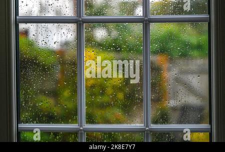 Raindrops on a glass window pane during wet weather England UK Stock Photo