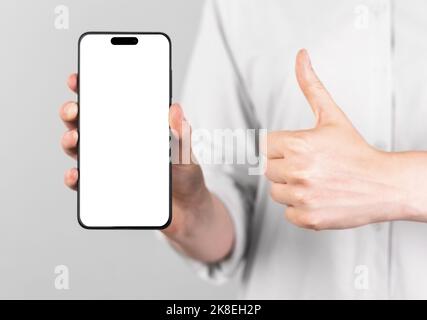 Minsk, Belarus October 23 2022 - iphone 14 pro screen mockup. Mobile phone mock up and thumbup gesture. High quality photo Stock Photo