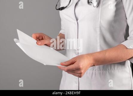 Doctors hand closeup, holding and studying abstract medical documents, papers. High quality photo Stock Photo