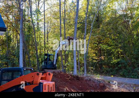 New development tractor working the clearing land on forest property ...