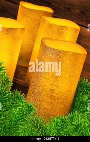 Four golden vintage LED real wax candles and fir branches Stock Photo