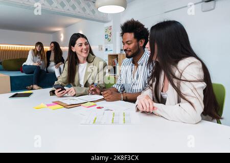 Businessman and two businesswomen working together on document in office Stock Photo
