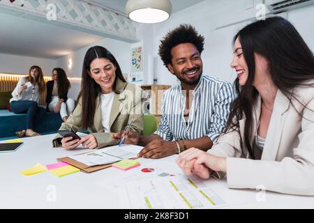 Happy colleagues working together on document in office Stock Photo