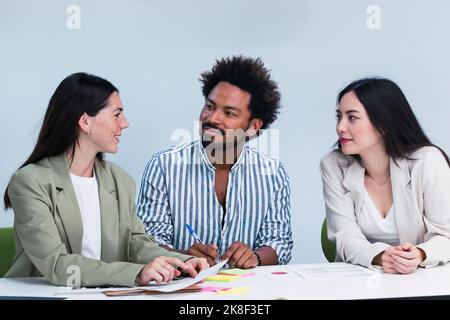 Three colleagues talking at desk in office Stock Photo