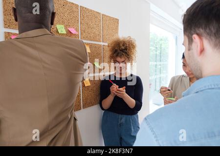 Business people standing in office brainstorming writing notes Stock Photo