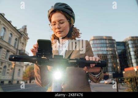 Young businesswoman with eyeglasses using smart phone in city Stock Photo