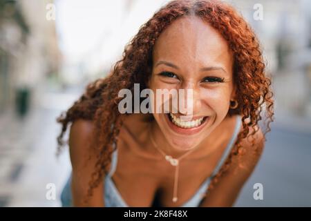 Cheerful young woman with curly hair Stock Photo
