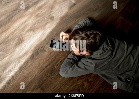 Boy playing game on smart phone at home Stock Photo