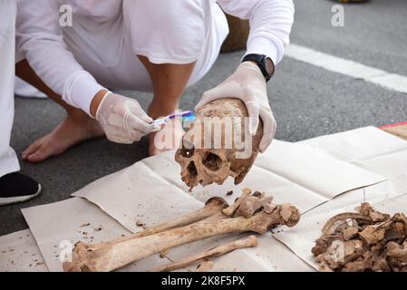 Bangkok, Thailand. 22nd Oct, 2022. Volunteers, participated in the tradition of exhuming the bodies of the deceased, unclaimed rising from the grave to clean human skeletons and collect them and prepare them for a merit-making ceremony according to religious belief of Thai people of Chinese descent At Teochew Chinese Cemetery (Wat Don Cemetery), Sathorn District, Bangkok. (Credit Image: © Teera Noisakran/Pacific Press via ZUMA Press Wire) Stock Photo