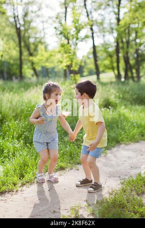 Cheerful cute girl holding hand of brother at park Stock Photo