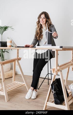 Female engineer working in modern office holding windturbine model Stock Photo