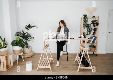 Young female engineer working in modern office sitting at desk Stock Photo