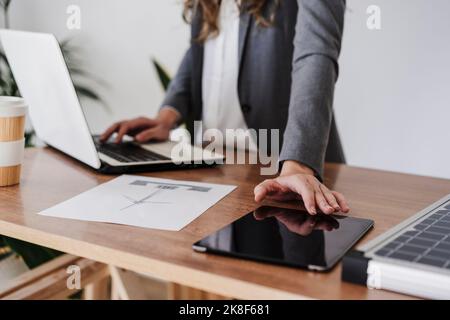 Young female engineer working in her modern office using digital tablet. close up Stock Photo