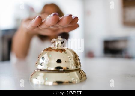Hand of businesswoman ringing service bell at restaurant Stock Photo