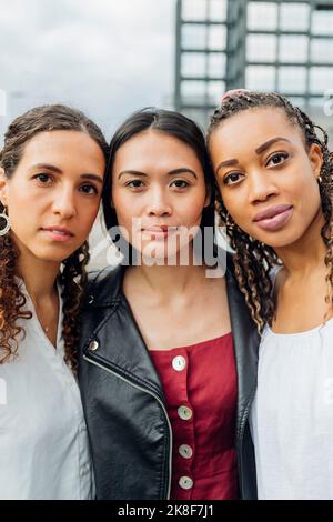 Young multiracial friends standing side by side Stock Photo