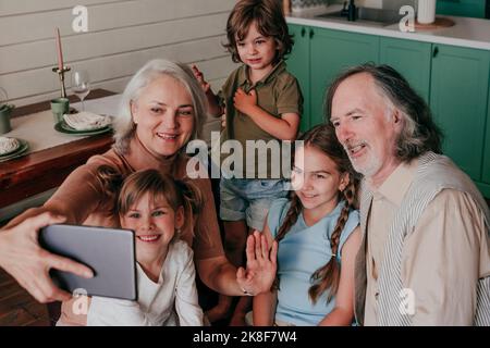 Grandmother with grandchildren taking selfie through tablet PC at home Stock Photo
