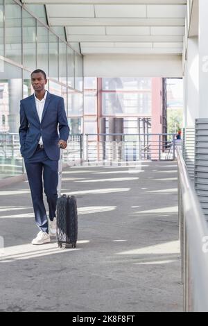 Young businessman walking with suitcase at railroad station Stock Photo