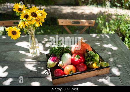 Fresh vegetables in wooden crate on table Stock Photo