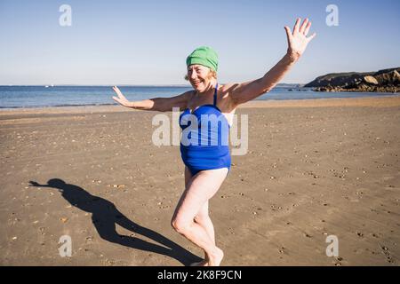 Senior woman wearing swimsuit having fun at beach Stock Photo