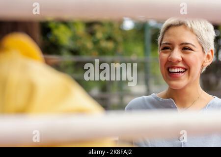 Happy non-binary person having fun with friend Stock Photo