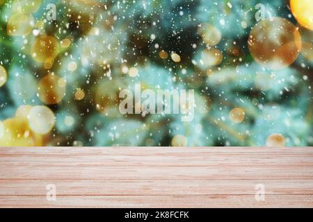 Light wooden desk against blurred background with snow and glowing Christmas lights Stock Photo