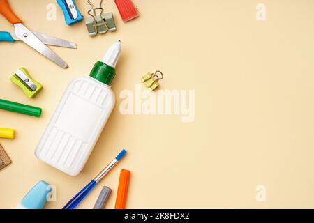 Composition with bottle of glue and different stationery on color background Stock Photo