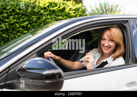 Happy mature woman sitting in car Stock Photo