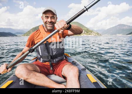 Happy man kayaking on lake Stock Photo