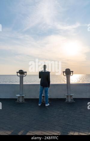 Young businessman on footpath at sunset Stock Photo