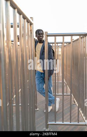Smiling young businessman leaning on railing Stock Photo