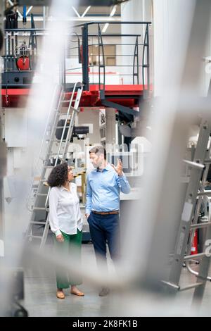 Businessman with colleague discussing in industry Stock Photo