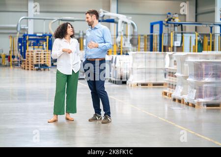Businessman with colleague discussing in industry Stock Photo