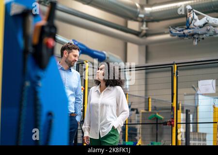 Businesswoman discussing with businessman at industry Stock Photo