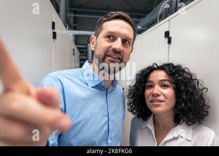 Businessman discussing with businesswoman in industry Stock Photo