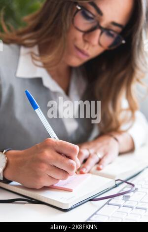 Lawyer making notes on sticky pad in office Stock Photo