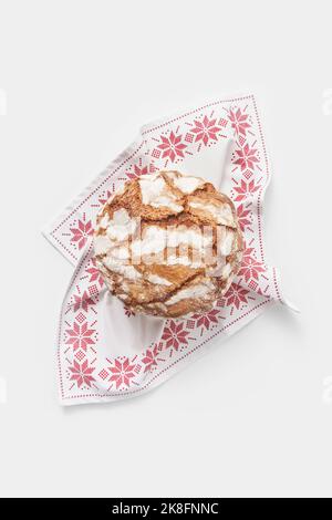 Panettone cake with crunchy crust on table napkin against white background Stock Photo