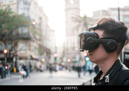 Young man wearing VR glasses in city Stock Photo