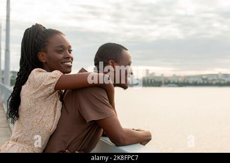 Thoughtful young woman standing with boyfriend on bridge Stock Photo